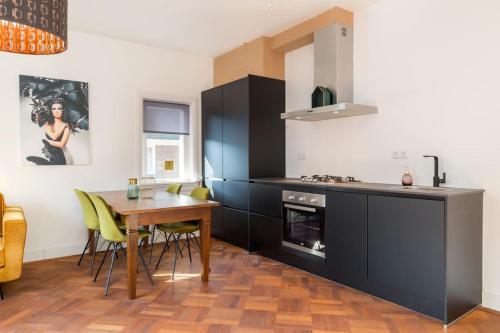 a kitchen with a wooden table and a dining room at Eindhoven City Suites Hertogstraat B Modern 2P in Eindhoven