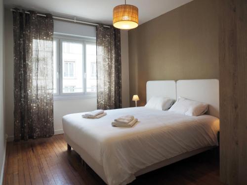 um quarto com uma grande cama branca e uma janela em Les Pingouins de la Gare em Brest