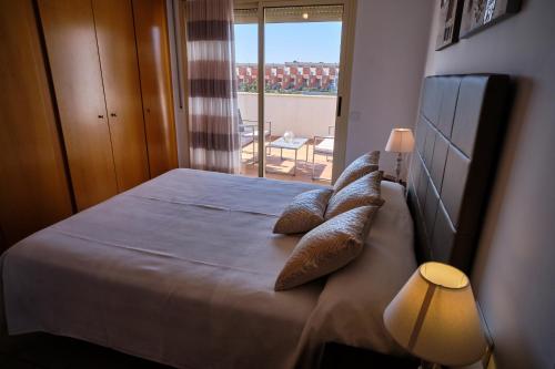 a bedroom with a bed with pillows and a window at Villa Almadrava in Tarragona