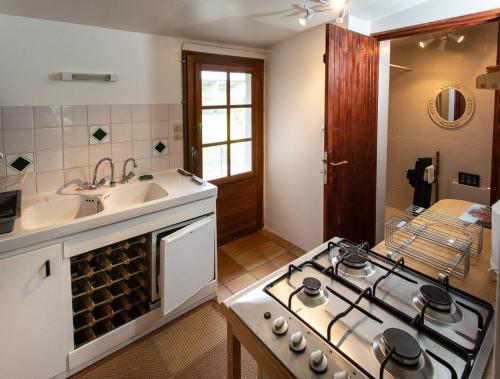 Il comprend une cuisine équipée d'une cuisinière. four supérieur à côté d'un évier dans l'établissement lehavredejulie, à Saint-Sigismond