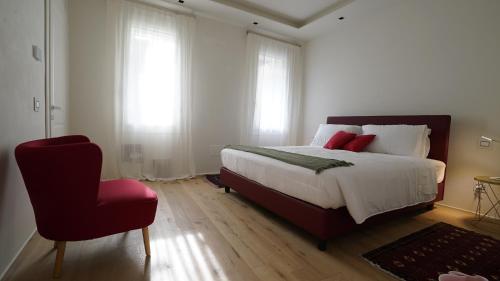 a bedroom with a bed and a red chair at Diana's luxury guest house in Padova