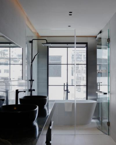 a bathroom with a tub and two sinks at Hotel Sapin in Pom Prap