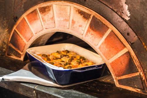a casserole dish of food in a brick oven at Hotel Sunroute Plaza Shinjuku in Tokyo