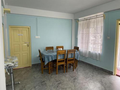 a dining room with a table and chairs and a window at Keeon Private Room Top in Shillong