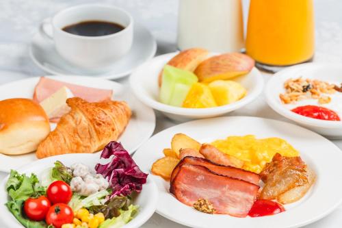 uma mesa com pratos de alimentos para o pequeno-almoço e uma chávena de café em Hotel Sunroute Plaza Shinjuku em Tóquio