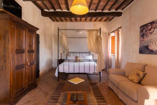 ein Wohnzimmer mit einem Bett und einem Sofa in der Unterkunft Tenuta Fattoria Vecchia in Scansano