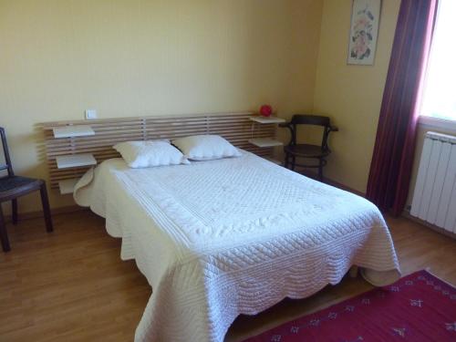 une chambre avec un grand lit blanc avec deux oreillers dans l'établissement villa à la campagne, à Sonnay