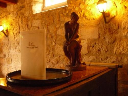 posąg kobiety siedzącej na stole w obiekcie Chateau de la Vieille Chapelle w mieście Lugon et l’Ile du Carney