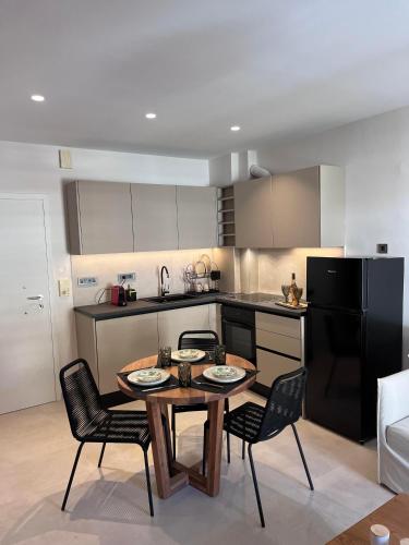 a kitchen with a table and chairs and a black refrigerator at Adam's Luxury Studio in Loutraki