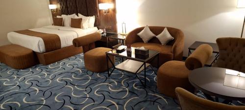 a hotel room with a bed and chairs at Bellevue Park Hotel in Taif