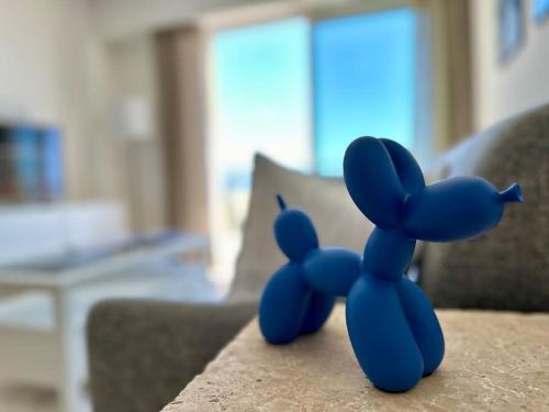 une souris bleue en peluche assise sur un canapé dans l'établissement Splendide vue mer, proche centre Beausoleil, à Beausoleil