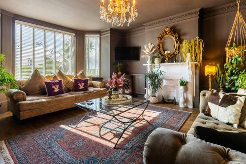 a living room with a couch and a chandelier at KIRA Beach Apartment, Hove Beach in Hove