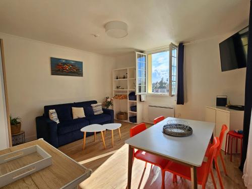 un salon avec un canapé bleu et une table dans l'établissement 2 Pièces, face casino, 20 mètres plage, wifi., à Trouville-sur-Mer