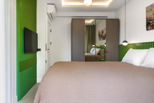 a bedroom with a bed and a green accent wall at Edem Villa Diamond in Kemer