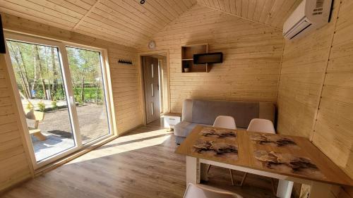a wooden room with a table and chairs and a window at Domki Wakacyjne "Morskie Wrota"Karwieńskie Błota in Karwieńskie Błoto Drugie