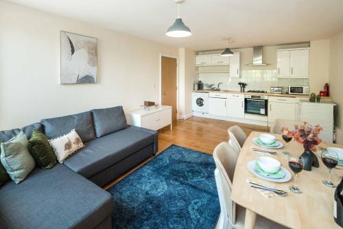 uma sala de estar com um sofá azul e uma mesa em Elephant&Castle Apartments By Sleepy em Londres