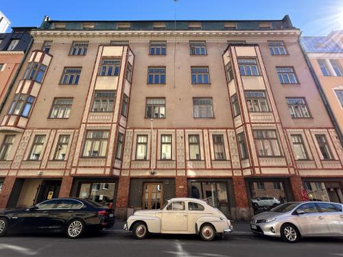 een oude auto geparkeerd voor een gebouw bij Luotsi 1911 Suite in Helsinki