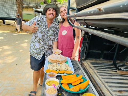a man and woman standing next to a table of food at La Maison Yala in Tissamaharama