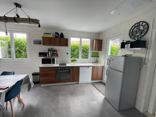 Il comprend une cuisine équipée d'un réfrigérateur et d'une table. dans l'établissement Maison bord de mer La faute sur mer, à La Faute-sur-Mer