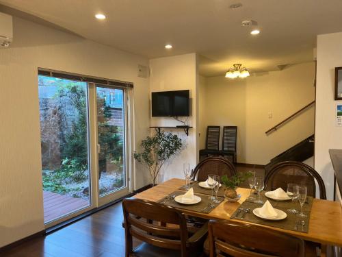 uma sala de jantar com uma mesa e cadeiras e uma janela em Populasunupuri - Vacation STAY 62945v em Otaru