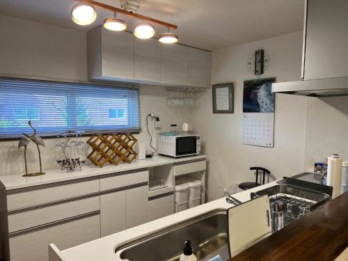 uma cozinha com um lavatório e um micro-ondas em Populasunupuri - Vacation STAY 62945v em Otaru