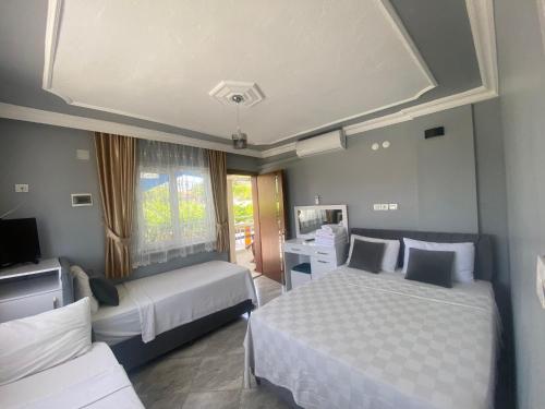 a hotel room with two beds and a television at Aspawa Hotel in Pamukkale