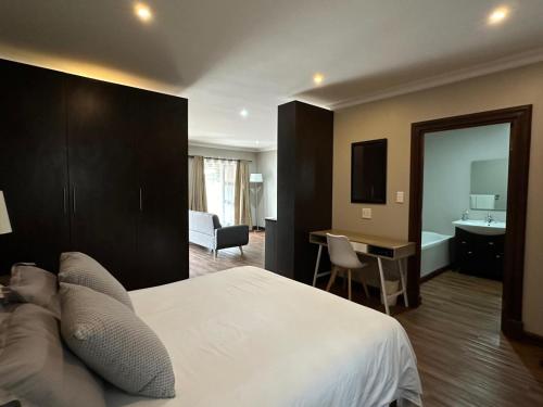 a hotel room with a bed and a bathroom at Cozy In Jozi in Edenvale