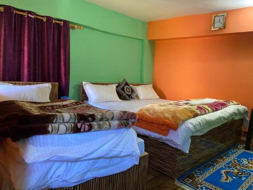 2 Betten nebeneinander in einem Zimmer in der Unterkunft Mountains Facing Homestay in Jyotirmath
