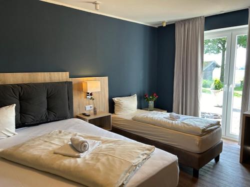 um quarto com 2 camas e uma parede azul em Pension zum Butterpatt em Sassenberg