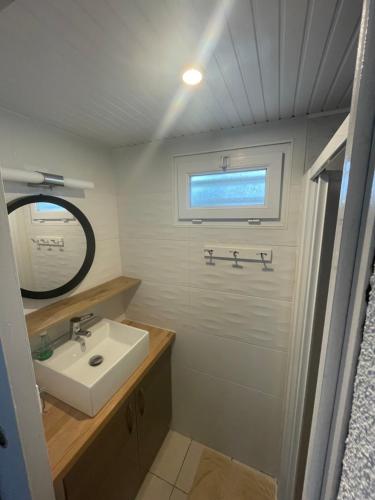 une salle de bain avec un lavabo et un miroir dans l'établissement Maison bord de mer La faute sur mer, à La Faute-sur-Mer
