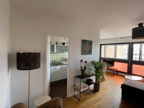 a living room with a couch and a table at Appartement lumineux 2 pièces Paris – idéal famille in Paris