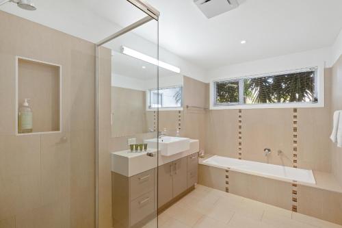 a bathroom with a sink and a bath tub and a window at Saltwater Breeze Retreat in Cowes