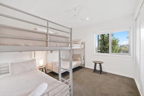 a bedroom with two bunk beds and a window at Saltwater Breeze Retreat in Cowes