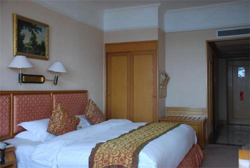 a bedroom with a large bed in a hotel room at Qingdao Oceanwide Elite Hotel in Qingdao