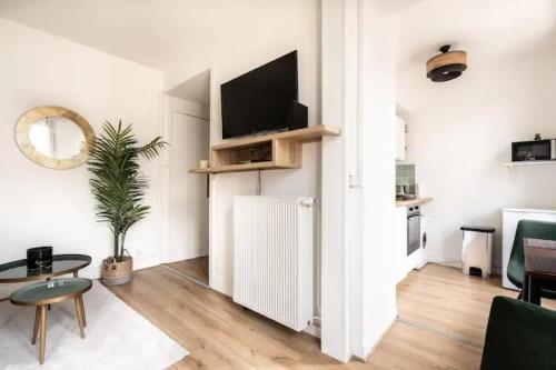 - un salon avec un radiateur et une télévision dans l'établissement Cocon aux portes de Paris, à Clichy