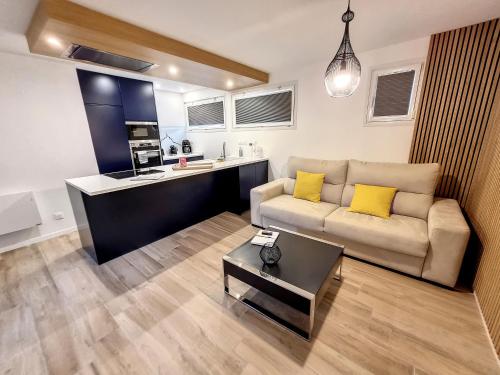 un salon avec un canapé et une cuisine dans l'établissement Mont Gîte Des Herbus Puccinellie avec Jacuzzi 2 personnes entre Granville et Mont Saint Michel, à Vains