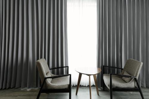 two chairs and a table in front of a window at SureStay Hotel by Best Western Vientiane in Vientiane