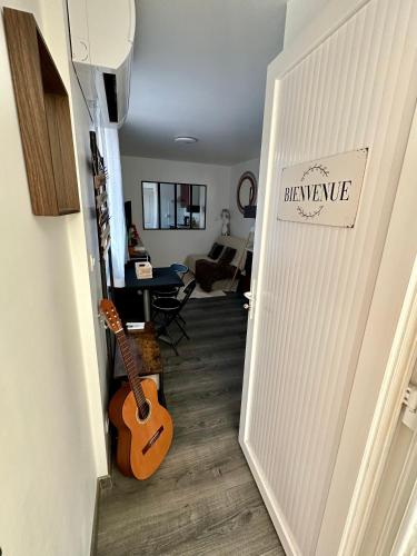 un couloir avec une guitare dans un salon dans l'établissement Charmant Studio 2 - Hyper centre - Musée Ingres-Tous Commerces à pied, à Montauban