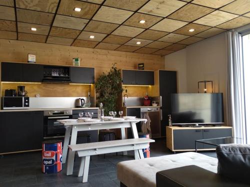 Il comprend un salon doté d'une table blanche et d'une télévision. dans l'établissement 2 ALPES, appart 60m2 déco tendance, à Les Deux Alpes