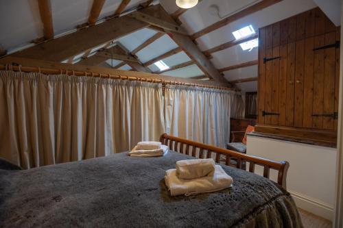 a bedroom with a bed with two towels on it at Mountain Cottage in Llanaelhaiarn