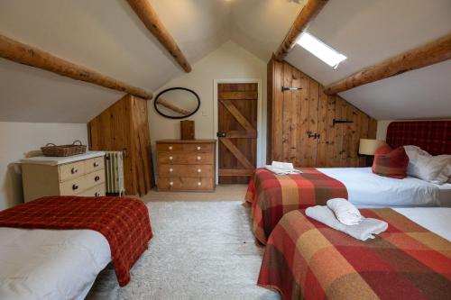 a bedroom with two beds and a door in a room at Mountain Cottage in Llanaelhaiarn