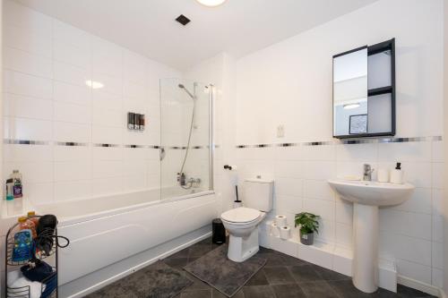 La salle de bains est pourvue de toilettes, d'un lavabo et d'une douche. dans l'établissement Manchester, Etihad Stadium View , Coop Live, Modern 2 bed apartment,, à Manchester