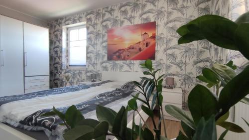 1 dormitorio con 1 cama con una pintura en la pared en Lake FeWo Santorini en Oberteuringen