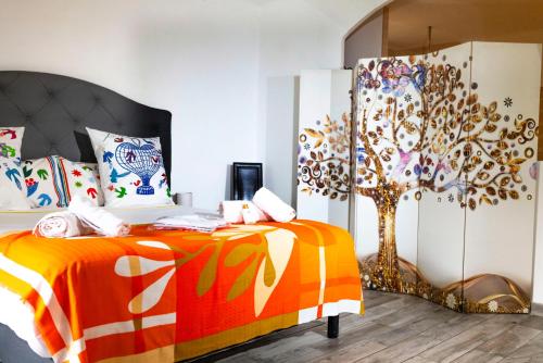 a bedroom with two beds and a tree on the wall at la Romana Luxe et sérénité au cœur de Saint-Tropez Suites spacieuses avec jardin enchanteur in Saint-Tropez