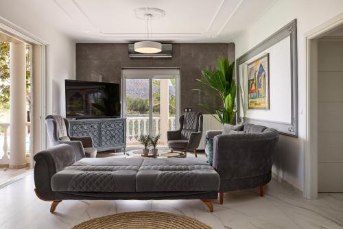a living room with a couch and chairs and a tv at Luxury White House - Villa & Weddings - Family Villa Near the Sea to the Famous Zorbas Beach in Stavros