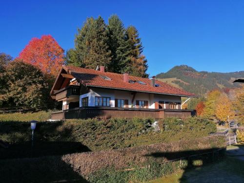 a house on top of a hill with trees at Ferienwohnung Alpenzauber in Obermaiselstein