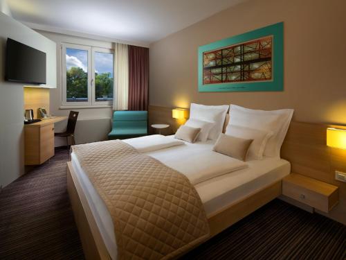 um quarto de hotel com uma cama grande e uma secretária em Ahotel Ljubljana em Ljubljana