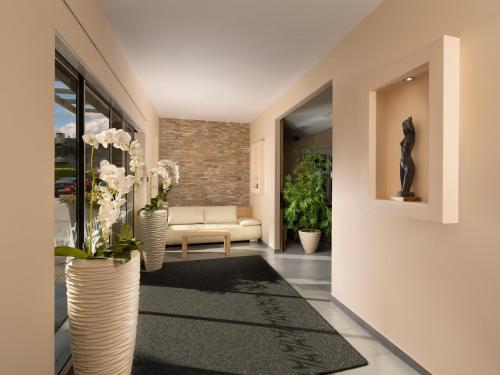 盧比安納的住宿－Ahotel Ljubljana，客厅配有沙发和鲜花花瓶