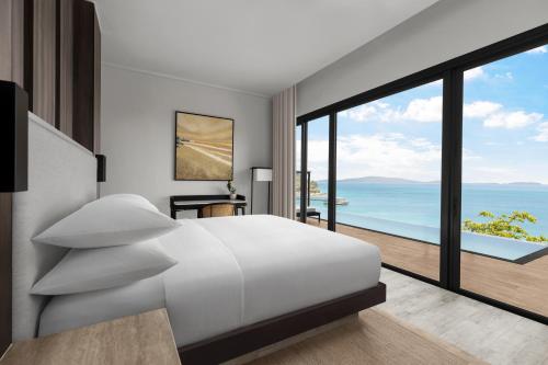 sypialnia z dużym białym łóżkiem i dużym oknem w obiekcie Perhentian Marriott Resort & Spa w mieście Wyspa Perhentian