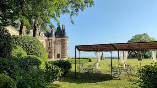 einen Pavillon mit Tischen und Stühlen vor einem Schloss in der Unterkunft Château de Montmirail in Montmirail